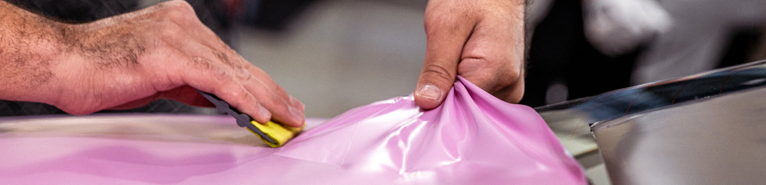 man applying vinyl wrap onto surface